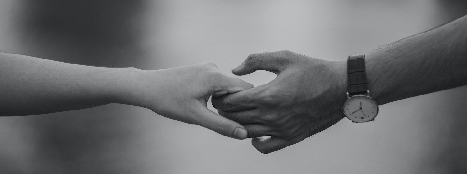 Mann und Frau halten sich an den Händen in Schwarz-Weiß