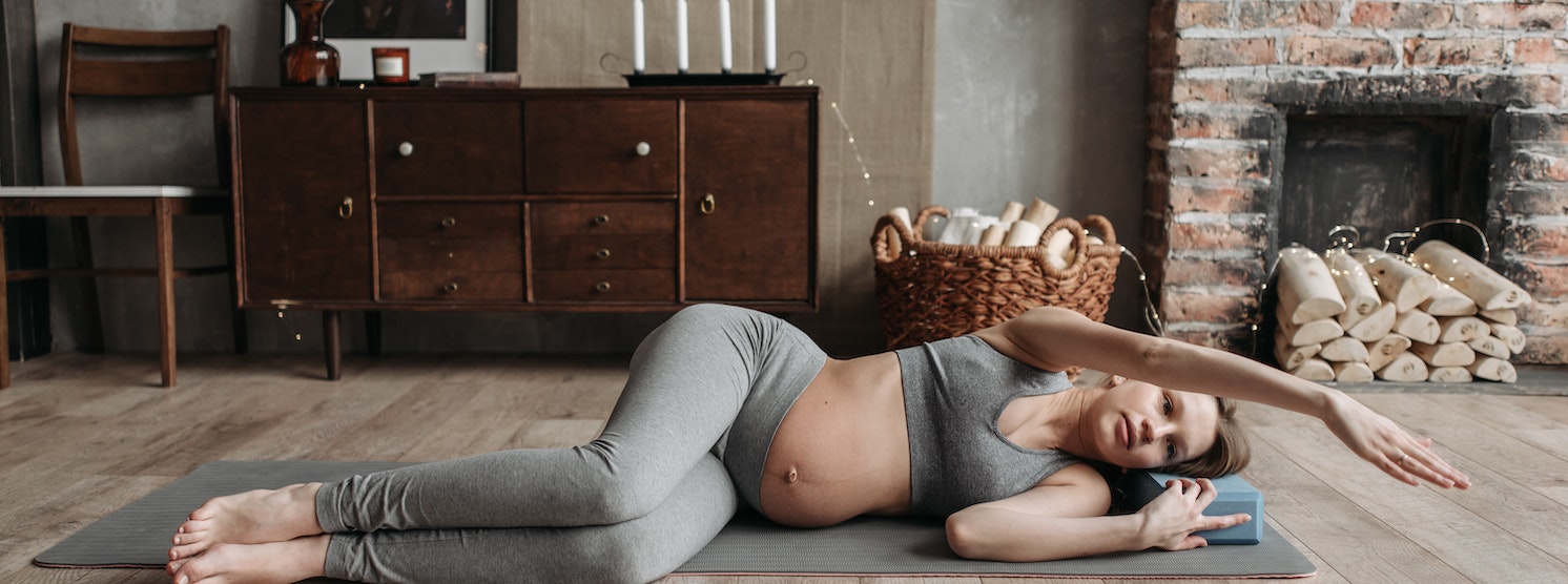 Schwangere Frau macht Rückenübungen