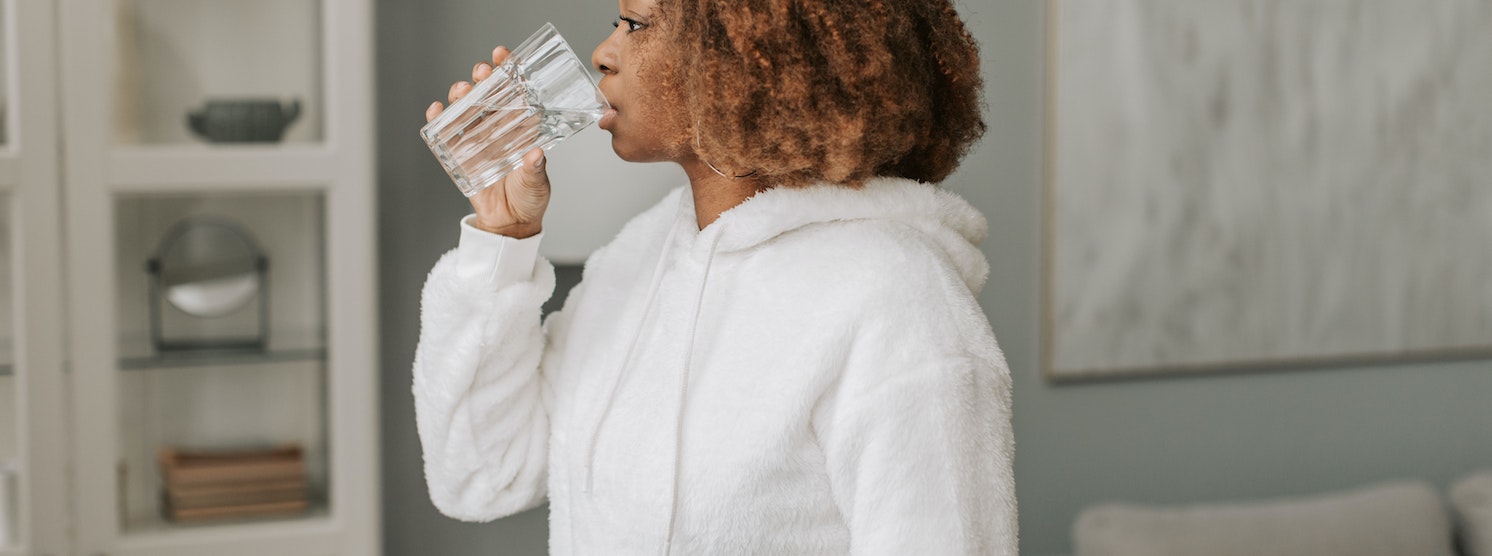 Schwangere Frau trinkt ein Glas Wasser